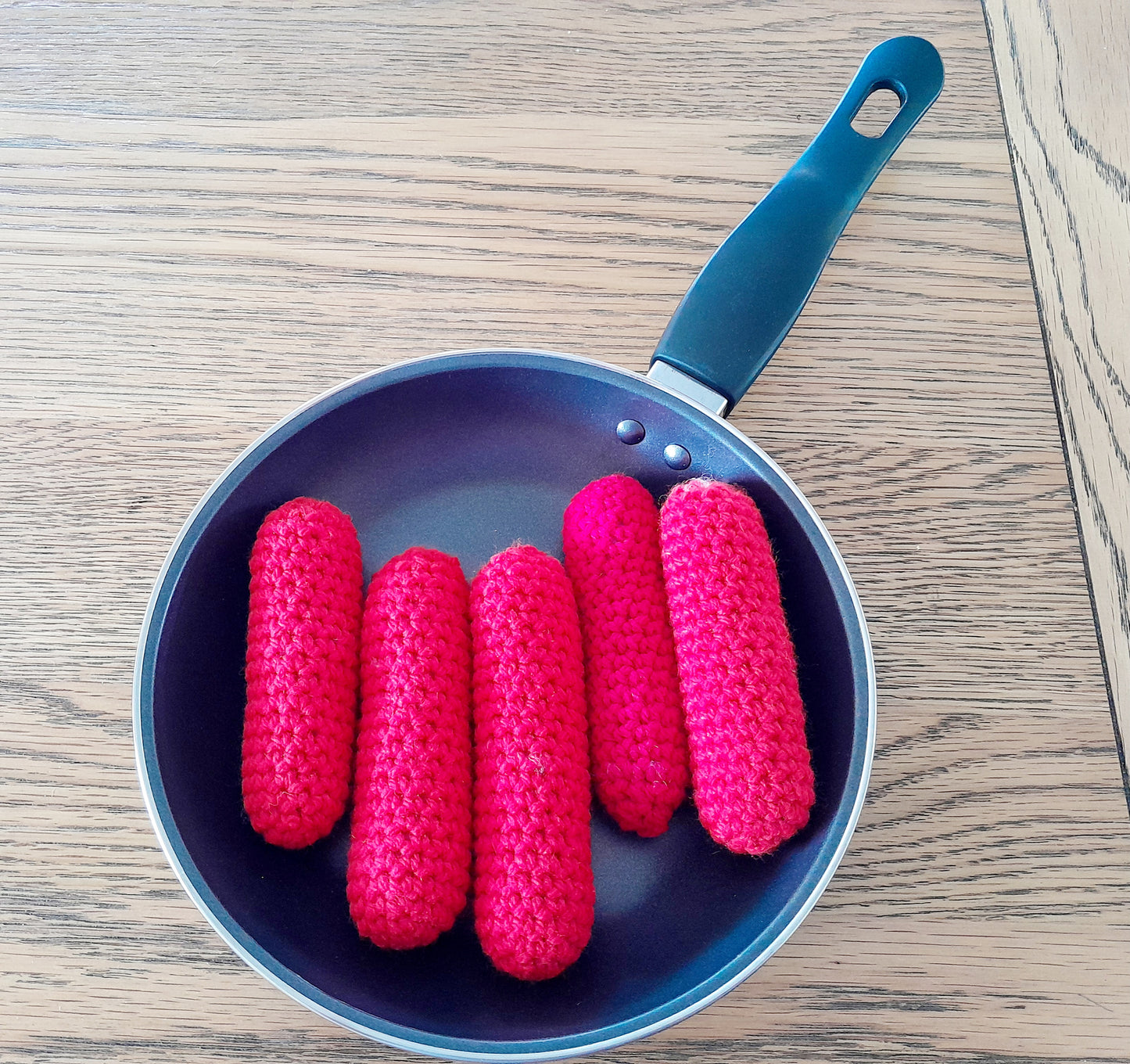 5 fat sausages sizzling in the pan